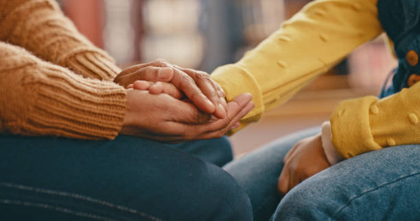 Two individuals demonstrating their autonomy and independence by holding hands amidst the quiet ambiance of a library.