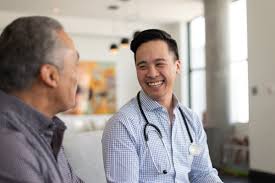 Two men with ME/CFS sitting at a table talking to a doctor.