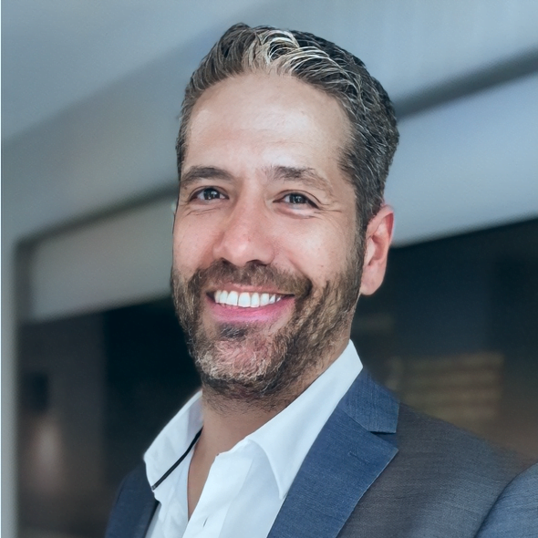 A smiling man in a suit and tie unaffected by mecfs.