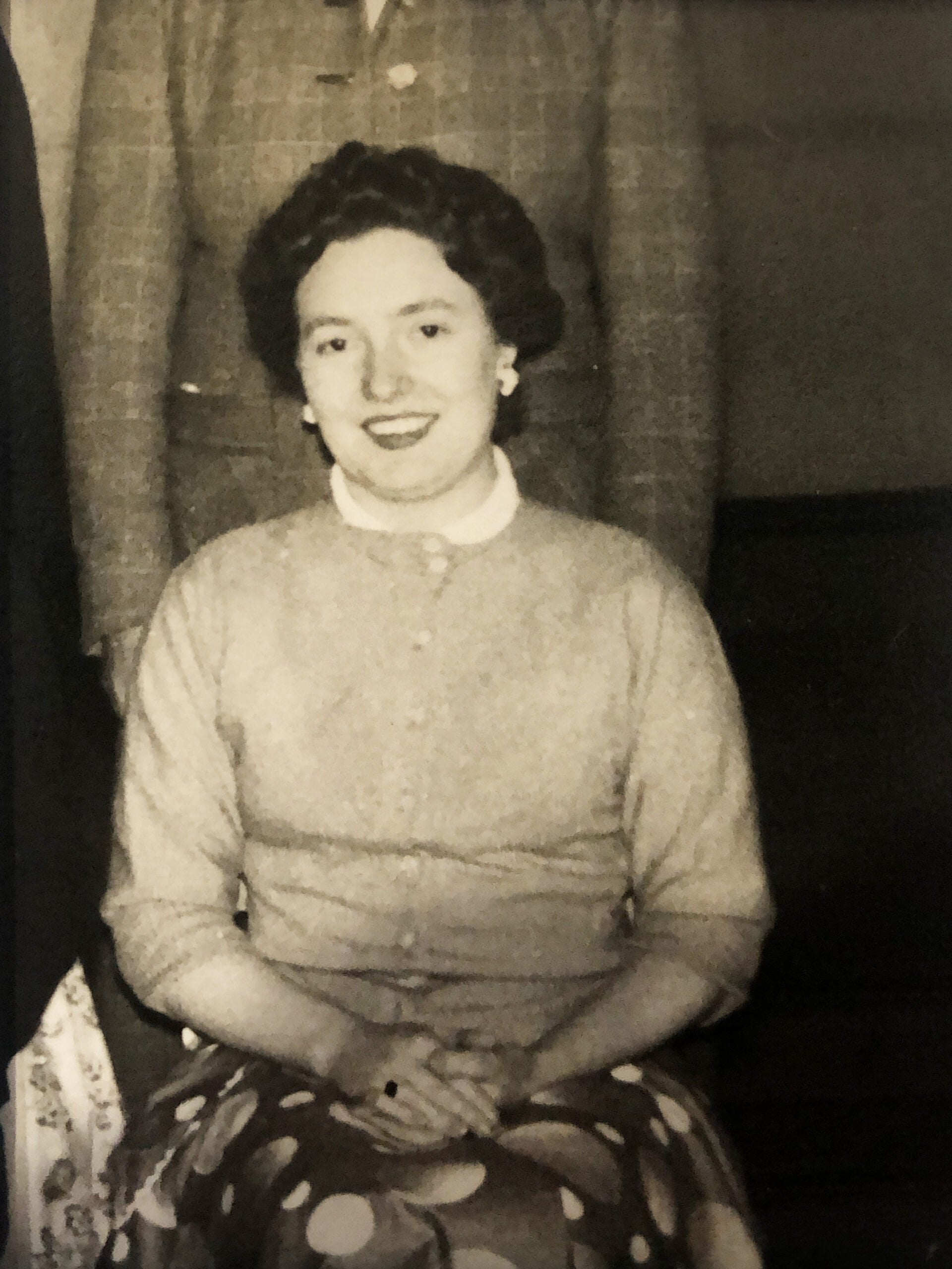 An old photo of a woman posing for a picture.