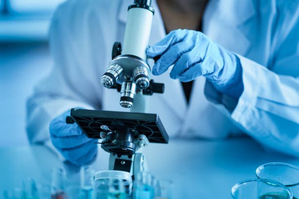 A scientist studying mecfs using a microscope in a laboratory.