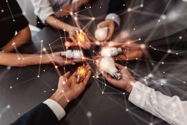 A group of mecfs patients holding light bulbs around a table.