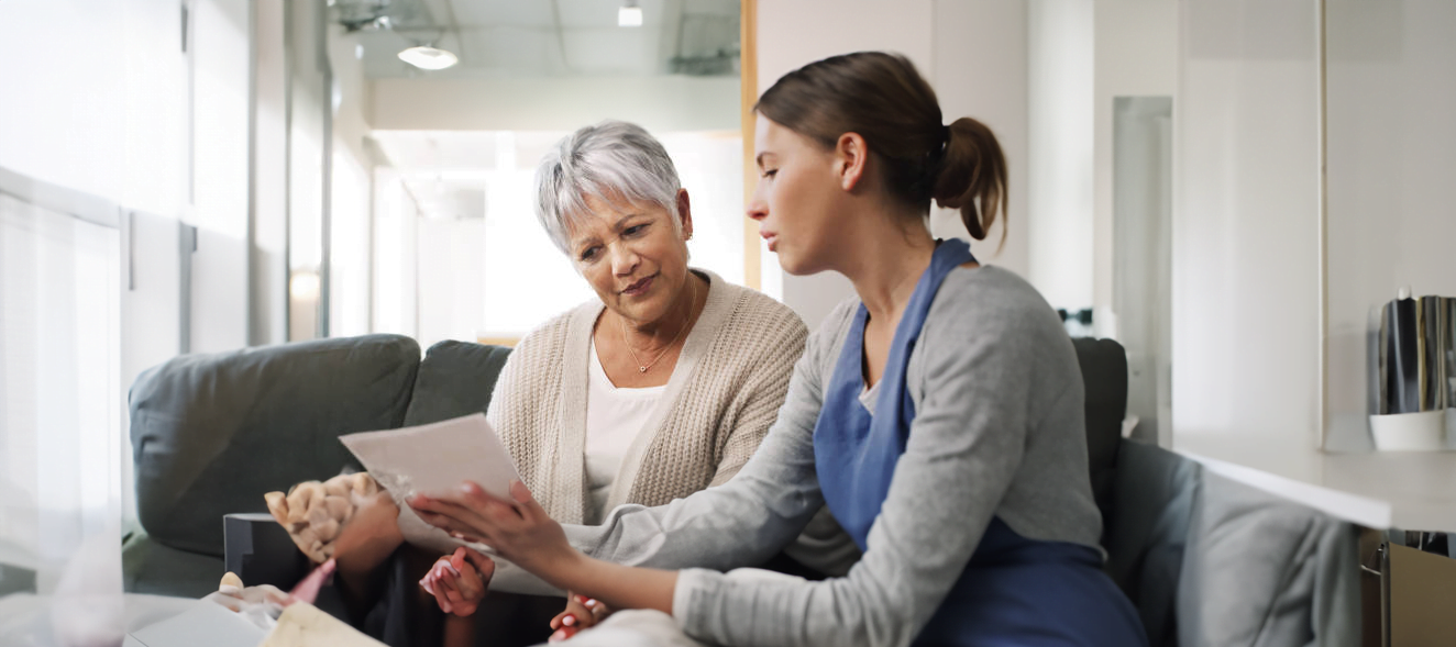 Two women sitting on a couch talking to each other about mecfs.